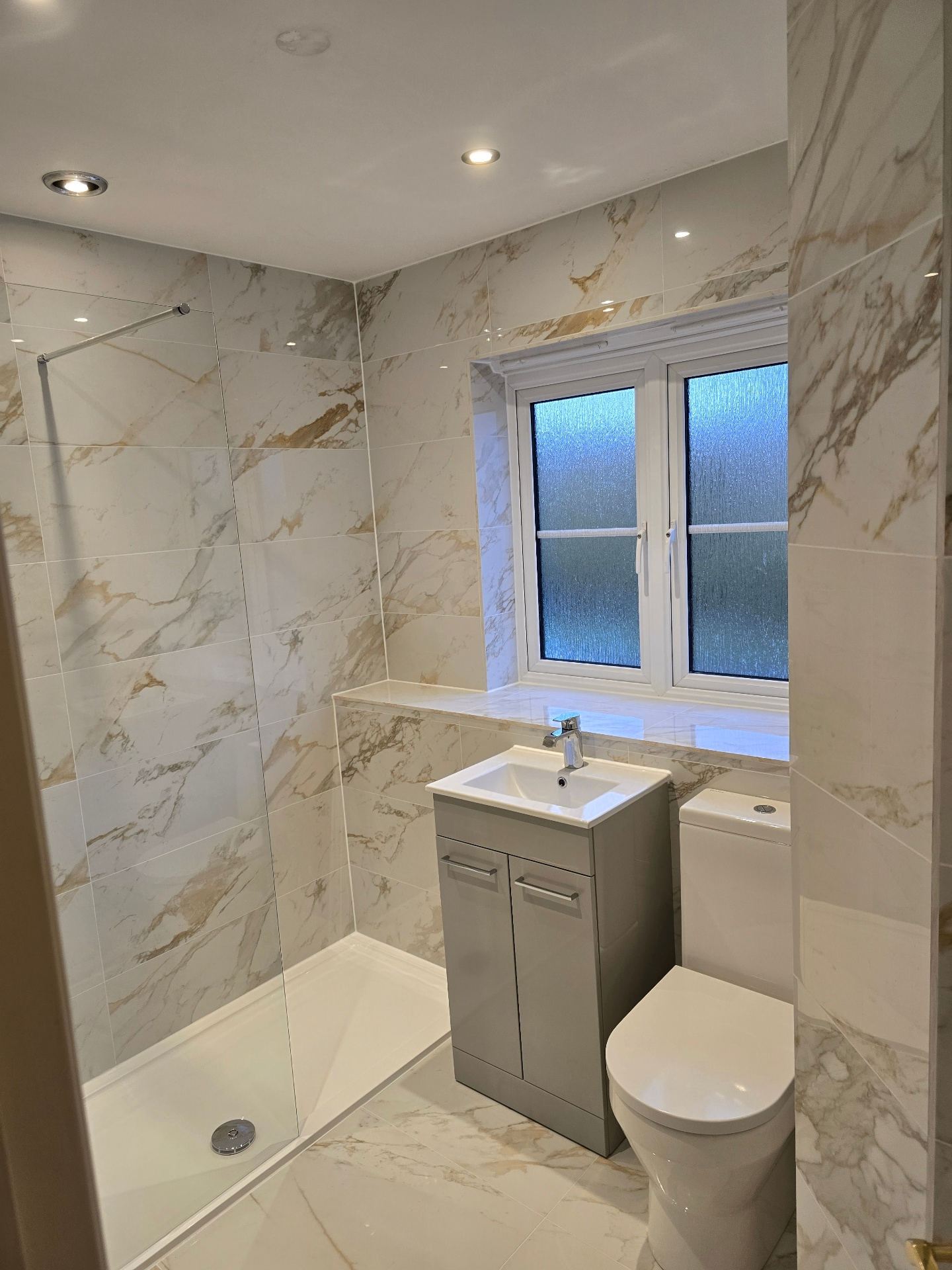 Calacatta marble walk-in shower room with grey vanity — real Blue Sky client home