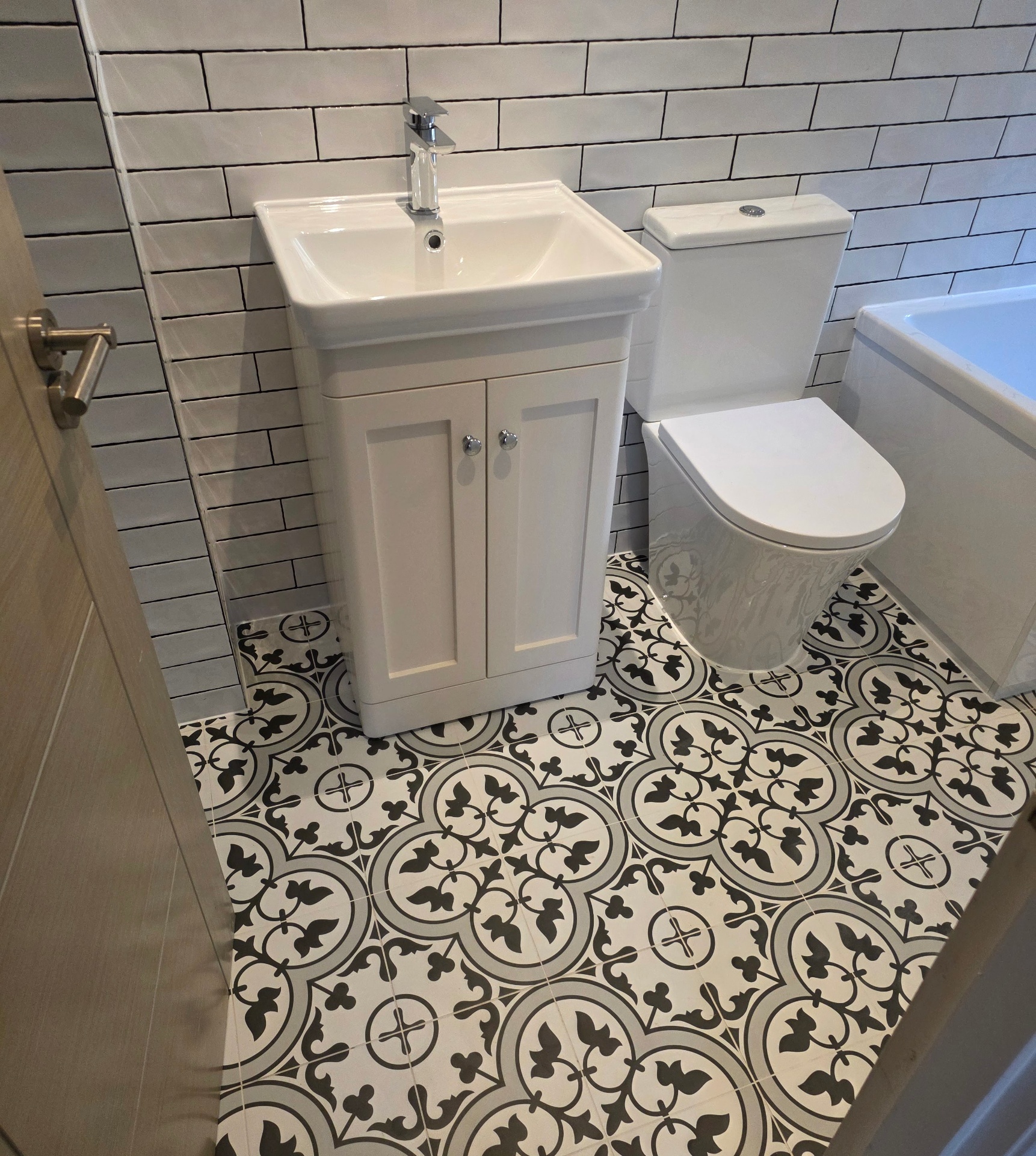 Cream vanity unit with chrome knobs and patterned floor tiling in a Tamworth cloakroom