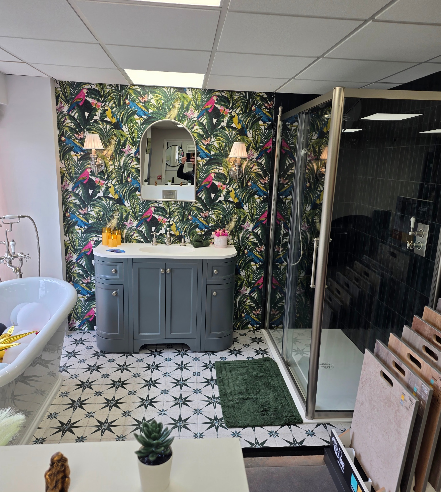 Curved traditional vanity unit with tropical wallpaper and freestanding bath in the Tamworth showroom