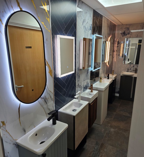 Compact vanity basins with backlit and LED mirrors against marble and herringbone feature walls in the Tamworth showroom