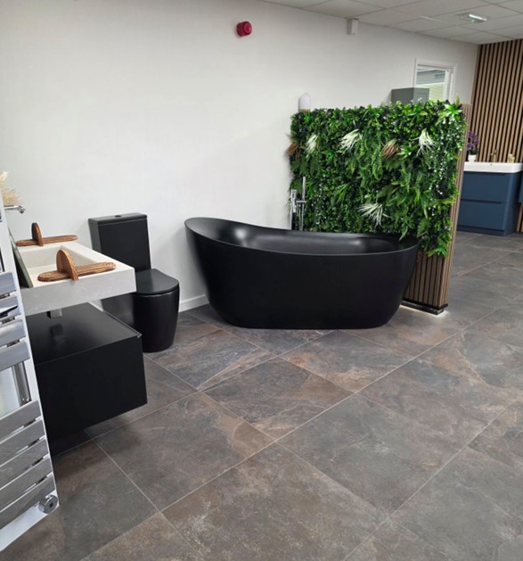 Matt-black freestanding bath with living-green feature wall display at the Blue Sky Tamworth showroom