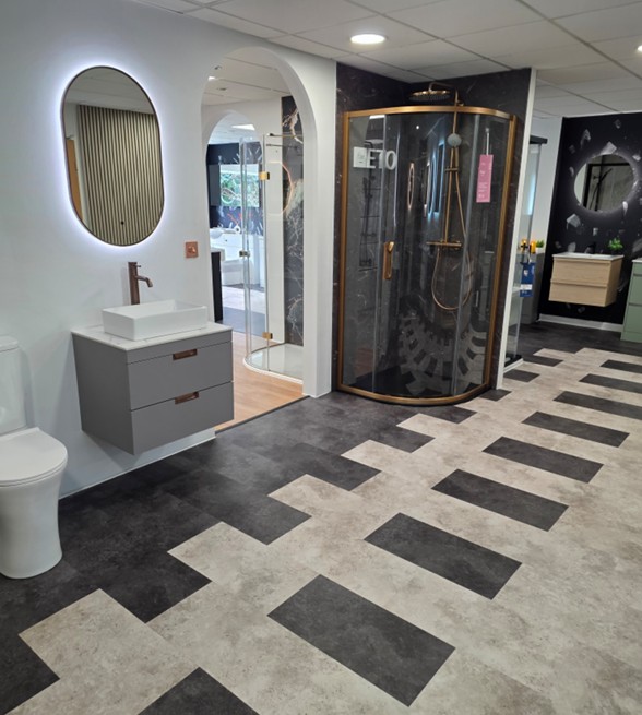 Gold-frame quadrant shower enclosure with grey vanity and backlit oval mirror in the Tamworth bathroom showroom
