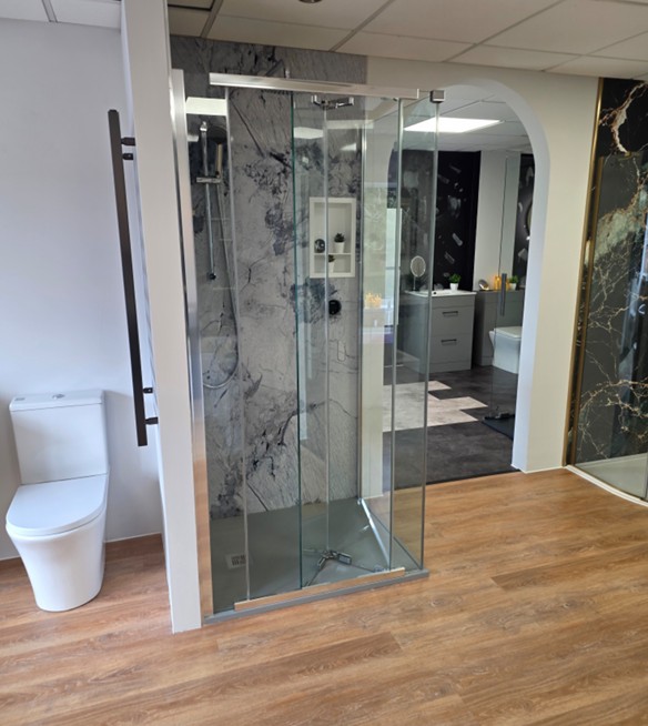 Walk-in shower enclosure with full-height marble panelling and chrome controls at the Tamworth bathroom showroom