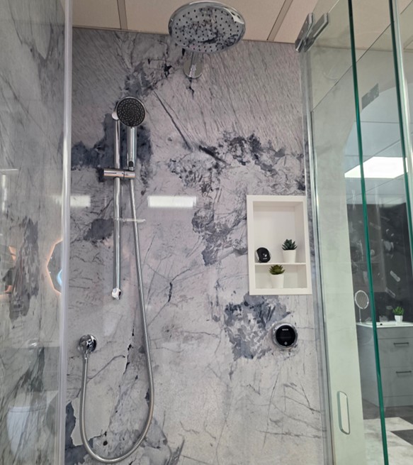 Marble-effect shower wall with rainfall head, handset and digital control display at the Tamworth showroom